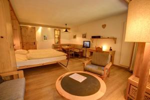 a bedroom with a bed and a table and a chair at Chesa Munteratsch 1-Zimmerwohnung 107 Typ B in Silvaplana