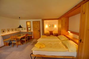 um quarto de hotel com duas camas e uma mesa em Chesa Munteratsch 1 1 2-Zimmerwohnung 204 Typ D em Silvaplana