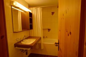 a bathroom with a sink and a bath tub at Chesa Munteratsch 1 1 2-Zimmerwohnung 204 Typ D in Silvaplana