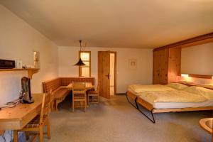 Schlafzimmer mit einem Bett, einem Schreibtisch und einem Tisch in der Unterkunft Chesa Munteratsch 1-Zimmerwohnung 206 Typ B in Silvaplana