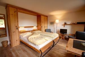 ein Schlafzimmer mit einem großen Bett und einer Holzwand in der Unterkunft Chesa Munteratsch 1-Zimmerwohnung 411 Typ A in Silvaplana