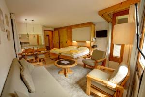 ein Schlafzimmer mit Bett und ein Wohnzimmer in der Unterkunft Chesa Munteratsch 2-Zimmerwohnung 410 Typ E in Silvaplana