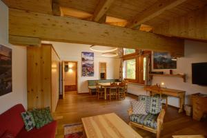 a living room with a table and a dining room at Chesa Munteratsch 2-Zimmerwohnung 301 Typ E in Silvaplana