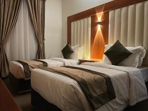 a hotel room with two beds and a window at Staytion Express Orjwan Lebanon in Jeddah