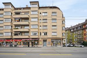 - un grand bâtiment en briques dans une rue de la ville dans l'établissement Central Apartment for City Explorers 222, à Zurich