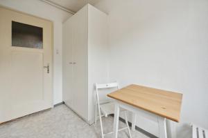 um quarto branco com uma mesa de madeira e uma porta em Central Apartment for City Explorers 222 em Zürich
