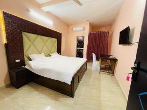 a bedroom with a large bed and a television at Hotel green park in Jabalpur