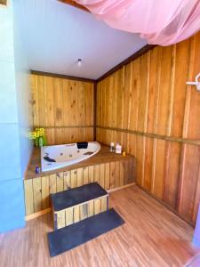 una sauna con bañera en una habitación con paredes de madera en Cabana Casa do Lago, en Ilha Grande
