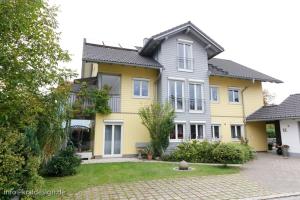 ein gelbes und graues Haus mit in der Unterkunft Sonnige Ferienwohnung, Rollstuhlgerecht, Hunde willkommen in Isny im Allgäu