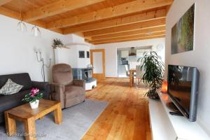 ein Wohnzimmer mit einem Sofa und einem TV in der Unterkunft Sonnige Ferienwohnung, Rollstuhlgerecht, Hunde willkommen in Isny im Allgäu