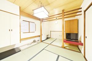 a living room with a television and wooden ceilings at Business Hotel Yamashiro in Tokyo