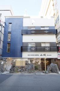 un edificio azul y blanco con un cartel para un hotel en Business Hotel Yamashiro, en Tokio