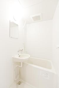 東京にあるビジネスホテル山城の白いバスルーム(シンク、鏡付)