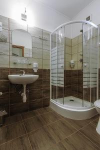 a bathroom with a shower and a sink and a toilet at Aranypatkó Fogadó-Étterem in Győrújbarát
