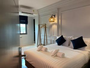 Wiang Ville Boutique Hotel في شيانغ ماي: غرفة نوم بسرير كبير عليها مناشف