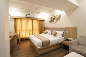 1 dormitorio con 1 cama, 1 silla y 1 sofá en Hotel PTC, en Indore