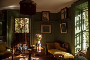 sala de estar con paredes verdes, mesa y sillas en The Historical Harcourt Suites en Dublín