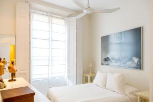 a bedroom with a white bed and a large window at Eva Recommends Gamazo in Seville