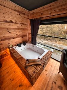 een bad in een kamer met een groot raam bij Medi Soho Bungalov in Rize