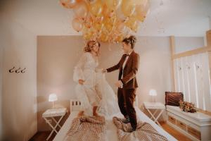 Una novia y un novio están saltando en las camas con globos en Eventbauernhof Wendelinshof 