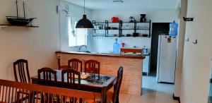 a kitchen with a table and chairs and a refrigerator at Aconchego em Floripa in Florianópolis