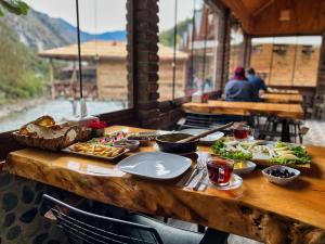 a wooden table with plates of food on it at Medi Soho Bungalov in Rize