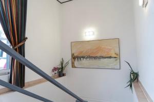 a painting hanging on a wall next to a staircase at Hotel Petit Wannsee in Berlin