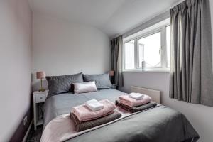 a bedroom with a bed with towels on it at Sandy House in Scarborough