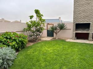 a backyard with a yard with green grass at Sandy Shores 3 Henties in Hentiesbaai