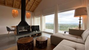 - un salon avec un canapé et une cheminée dans l'établissement Casas Fonte da Tapada, à Trancoso