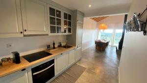 a kitchen with white cabinets and a sink and a table at Casas Fonte da Tapada in Trancoso