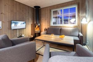 een woonkamer met een tafel en stoelen en een televisie bij Geilolia Hyttetun in Geilo