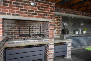 a kitchen with a brick fireplace and a sink at OnQ Accommodation in Bellville