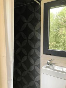 a bathroom with a sink and a window at Joy Tiny House in Saint-Germain-le-Vieux