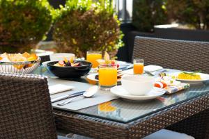 a table with food and orange juice on it at SANA Silver Coast Hotel in Caldas da Rainha