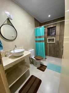 y baño con lavabo, aseo y espejo. en Casa anexa com lareira, en Campos do Jordão