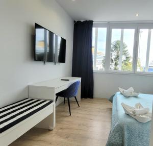 - une chambre avec un bureau, un lit et une télévision dans l'établissement Luz de Cádiz, à Cadix