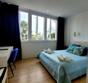 - une chambre avec un lit orné de 2 fleurs blanches dans l'établissement Luz de Cádiz, à Cadix