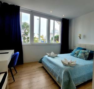 a bedroom with a bed with two white flowers on it at Luz de Cádiz in Cádiz +40 photos