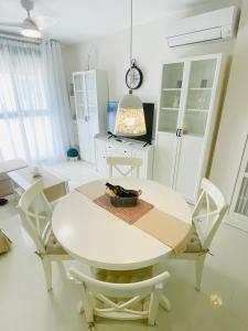 een witte eetkamer met een witte tafel en stoelen bij Town Apartment direkt im Zentrum von Denia in Denia