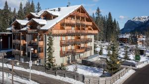 an apartment building with a snow covered roof at Maribel Hotel in Madonna di Campiglio
