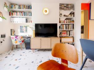 a living room with a tv and a chair at Pass the Keys Designer Apartment in the heart of Euston in London