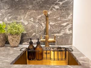a kitchen sink with two bottles on a counter at Pass the Keys Designer Apartment in the heart of Euston in London