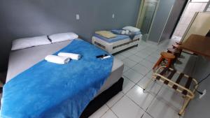 1 dormitorio con 1 cama con sábanas azules y toallas en Estúdios Individual na Meia Praia ar, wifi, vaga, cozinha, tv smart - 6 x no cartão sem juros, en Itapema