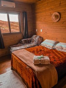 a bedroom with two beds in a log cabin at Chalé Guadalupe - Condomínio Altos da Serra in Bom Jardim da Serra