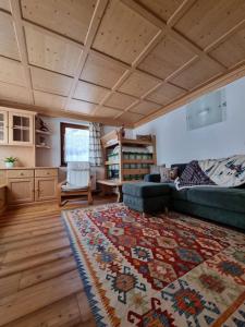 sala de estar con sofá y alfombra en Appartamento ai larici, rustico ed elegante en Varena