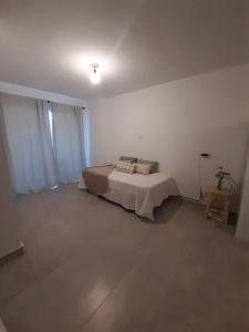 a bedroom with a bed in a white room at Apart Plaza in San Salvador de Jujuy