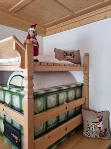 a wooden bunk bed with a teddy bear sitting on top at Appartamento ai larici, rustico ed elegante in Varena