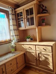 uma cozinha com armários de madeira e uma janela em Appartamento ai larici, rustico ed elegante em Varena