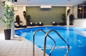 a large swimming pool in a hotel lobby with a blue pool at Quality Hotel Winn in Gothenburg